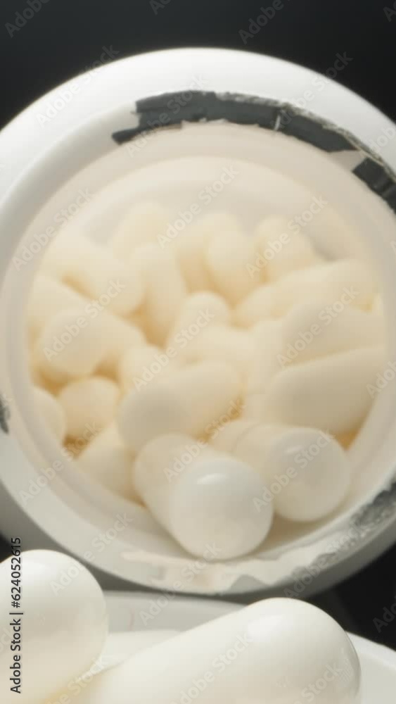 White jar with pills, capsulamia. Dolly slider extreme close-up inside. Laowa Probe Vertical video. White jar with pills, capsulamia. Dolly slider extreme close-up inside. Laowa Probe Vertical video.