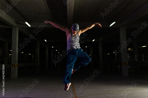 Urban performer doing a street dance at night in a parking lot