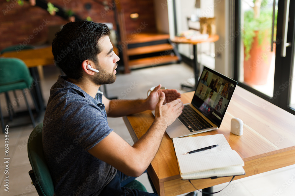 Young man working at the cafe and having a video call