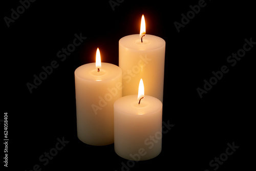 Burning white candles isolated on black background.