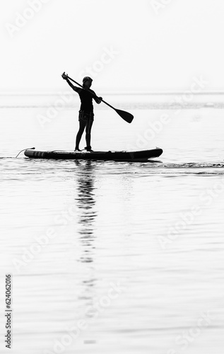 silhouette of a person stand up paddling
