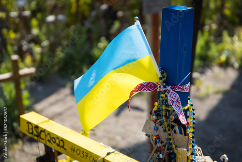 Ukrainian flag waving on a cross at a war memorial photo