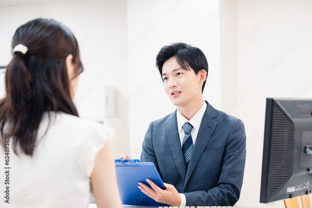 窓口で顧客の要望を聞く男性スタッフ