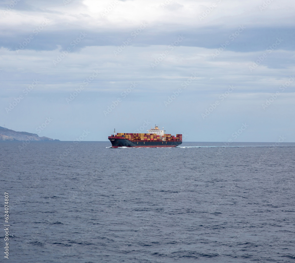 Container cargo ship full loaded is sailing in open sea background. Import export, water transport. Container cargo ship full loaded is sailing in open sea background. Import export, water transport.