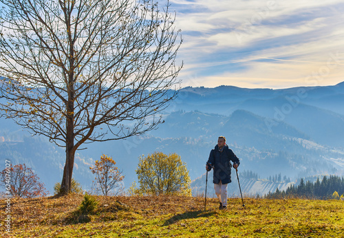 A young man who hikers enjoys a break look at the top of the mountain. People adventure travel.