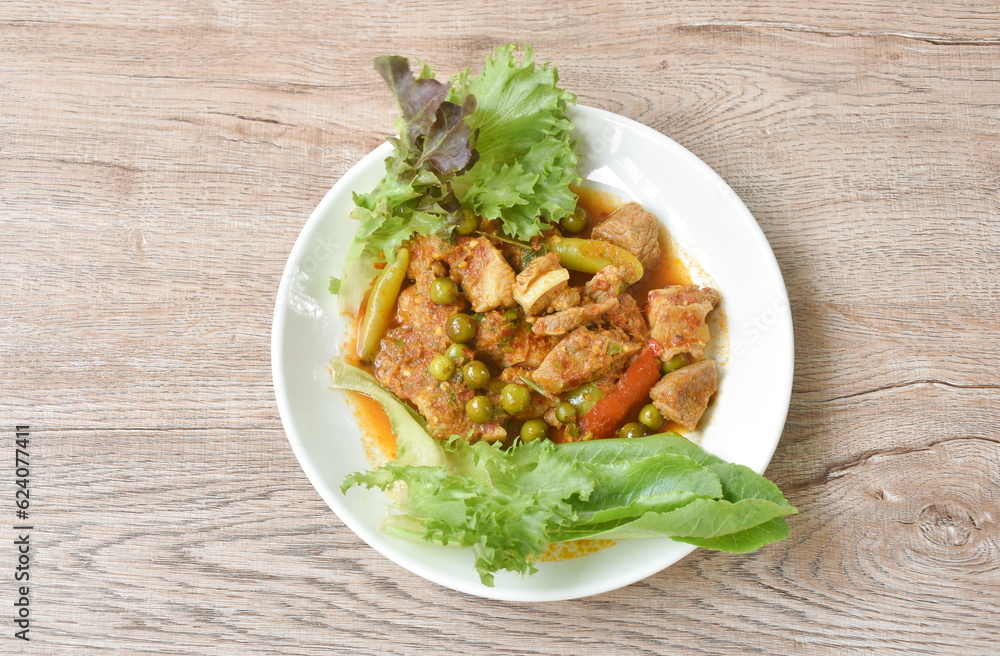 spicy fried pork bone with curry and basil leaf with fresh vegetable on plate spicy fried pork bone with curry and basil leaf with fresh vegetable on plate
