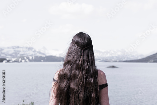 Frau mit langen Haaren an einem Seeufer