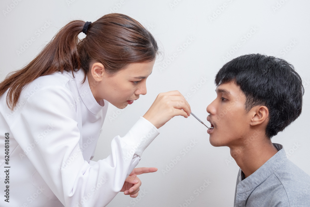 Beautiful young woman dentist in uniform using dental mirror to examine the teeth in the patient's mouth. Beautiful young woman dentist in uniform using dental mirror to examine the teeth in the patient's mouth.