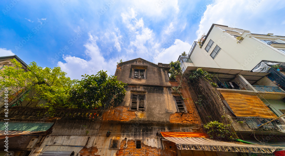 Old Apartment house block in Hanoi Old Quarters Vietnam narrow tall houses with plants on exterior of the building colourfully decorated 