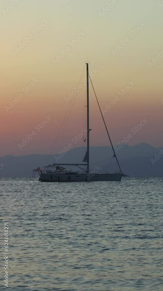 Alone sailboat at sunset. Atmospheric seascape. Vertical video for social media. Alone sailboat at sunset. Atmospheric seascape. Vertical video for social media.