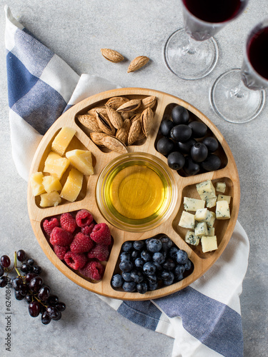  Wooden menagerie with assorted cheese, berries and nuts. Cheese plate, snacks for the festive table photo