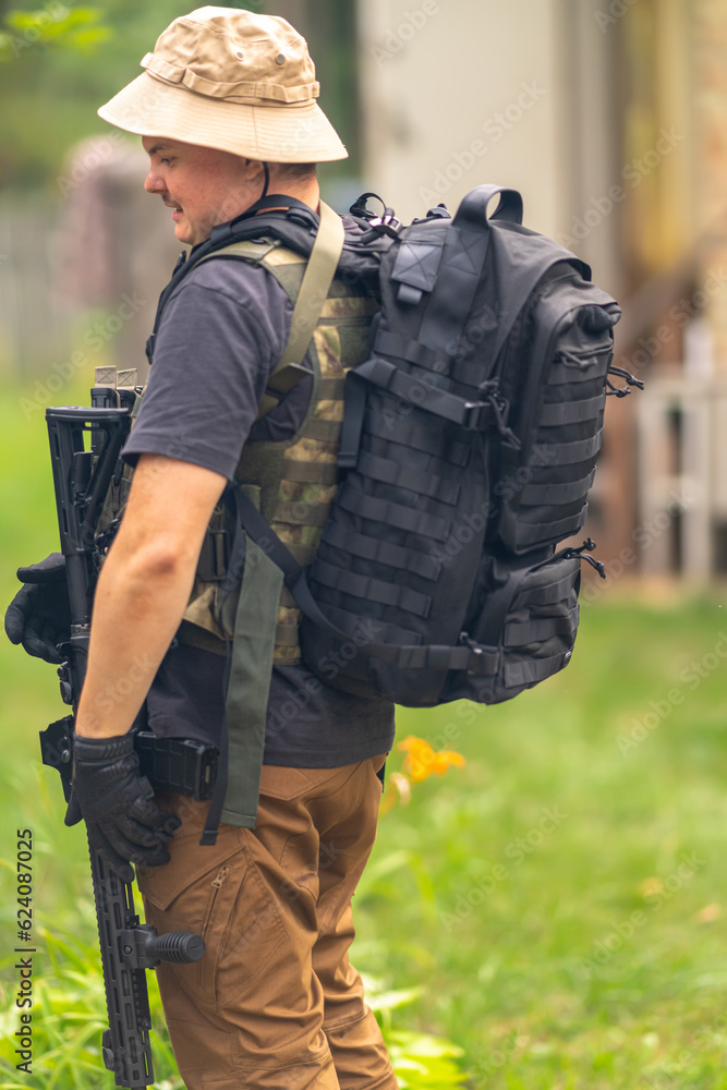 A man with a rifle, a backpack and a bulletproof vest