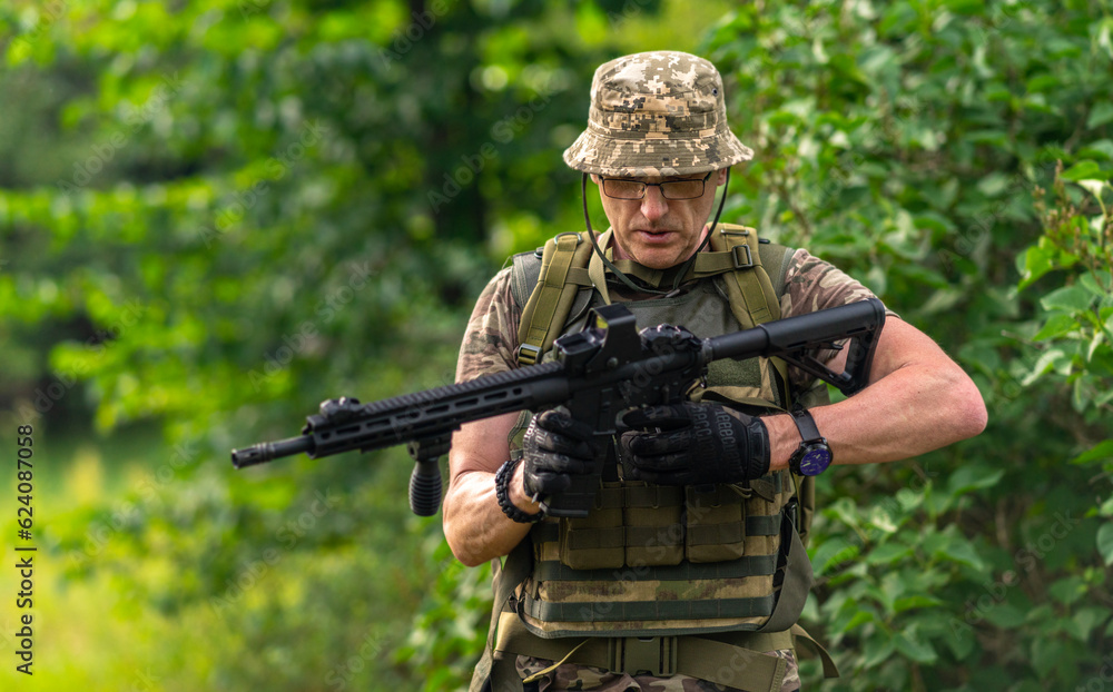 A soldier attaches a magazine to a rifle