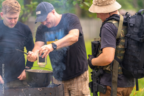 Obraz na płótnie Three soldiers preparing lunch in the field w salonie