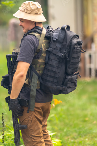 Obraz na płótnie A man with a rifle, a backpack and a bulletproof vest w salonie