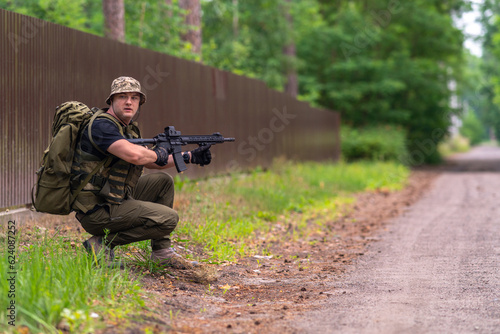 A soldier or mercenary is looking along the sides of the road