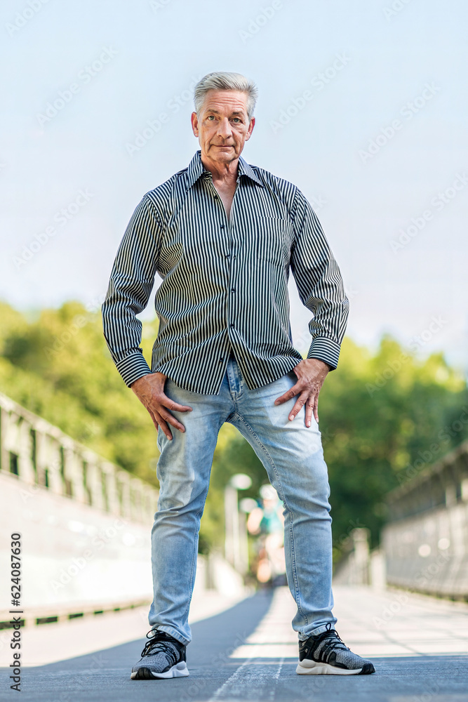 Casual lifestyle portrait of an elderly man in a park in summer outdoors
