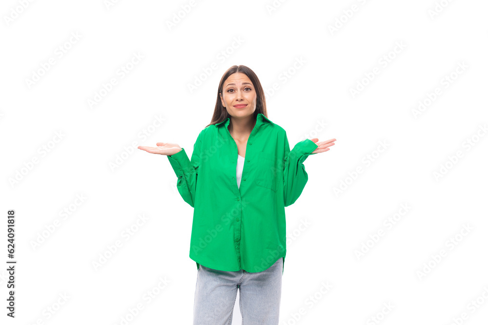 stylish slim young brunette woman with makeup in a green shirt shrugs her shoulders on a white background with copy space stylish slim young brunette woman with makeup in a green shirt shrugs her shoulders on a white background with copy space