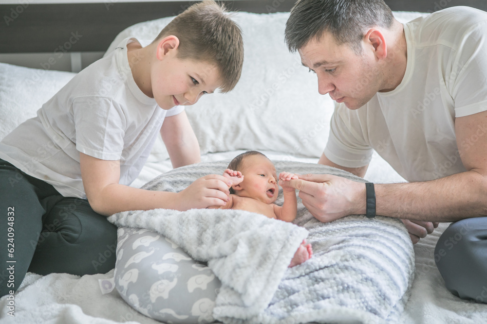 Portrait of father and his four son holding his newborn baby