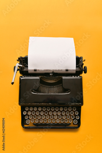 Vintage typewriter with a blank blank sheet on a yellow background. Banner, advertising layout with place for your text.
