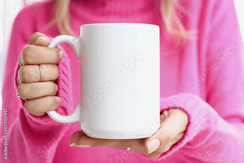 Obraz na płótnie Girl is holding white 15 oz mug in hands with pink sweater
