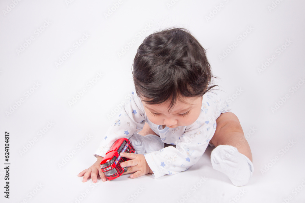 Beautiful photo of baby playing on light background in photo studio. Family and baby concept. Beautiful photo of baby playing on light background in photo studio. Family and baby concept.