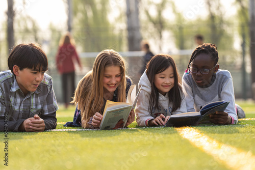 Lovely pupils on reading on the grass
