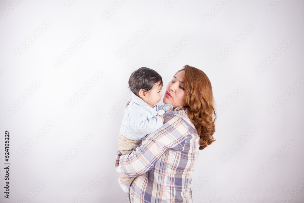 Beautiful photo of mom holding baby on light background in photo studio. Family and baby concept. Beautiful photo of mom holding baby on light background in photo studio. Family and baby concept.