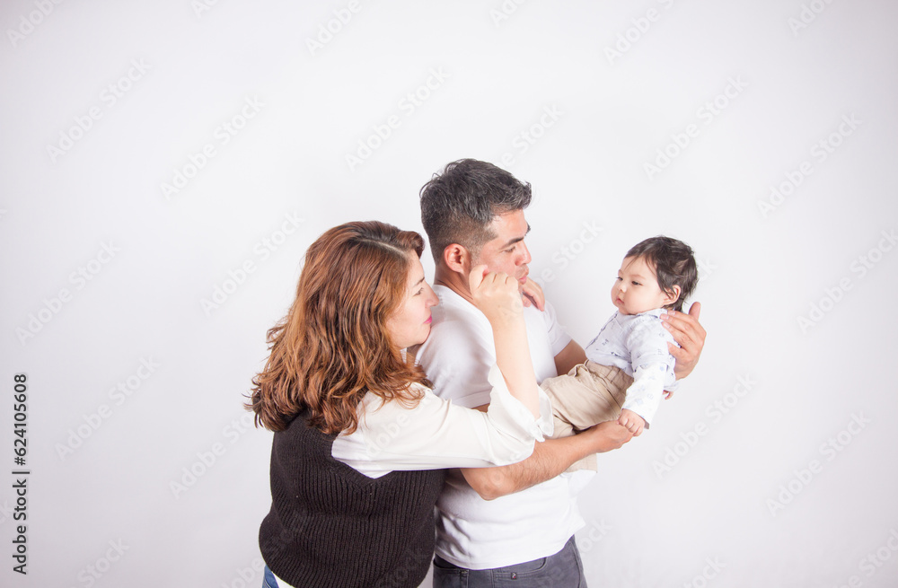 Beautiful photo of Dad and mom being affectionate with baby on light photo studio background. Family and baby concept. Beautiful photo of Dad and mom being affectionate with baby on light photo studio background. Family and baby concept.