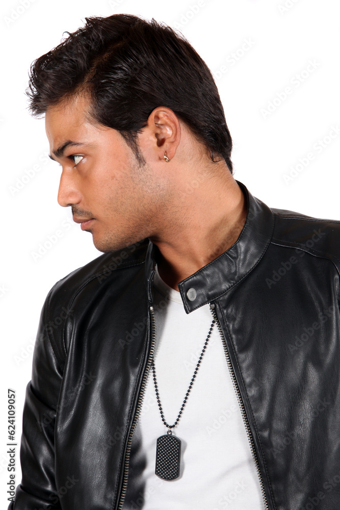 A young Indian guy in a black leather jacket staring at someone.