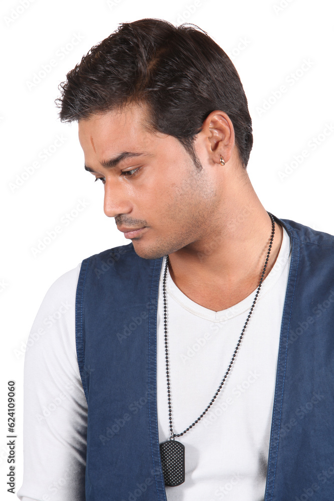 A young sad Indian guy lost in his thoughts, on white studio background.