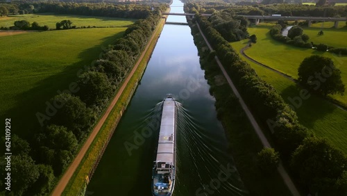 Aerial view of global shipping cargo ship navigating through the inland canal of wesel-datteln, Germany.