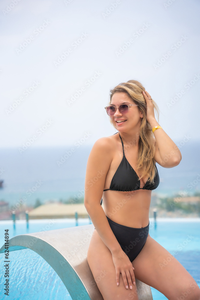 Portrait of beautiful woman in swimwear relaxing in swimming pool in resort