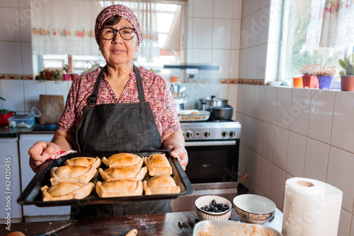 Tableau sur toile Flavors of Heritage: Latin Elderly Woman Preparing Chilean Baked Beef Empanadas