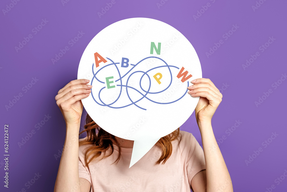 Dyslexia concept. Girl holding a poster with the image of letters isolated on a lilac background - obrazy, fototapety, plakaty 