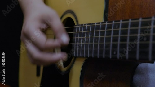 Musician playing on acoustic guitar. Close-up shot.