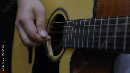 musician playing fingerstyle guitar. close up