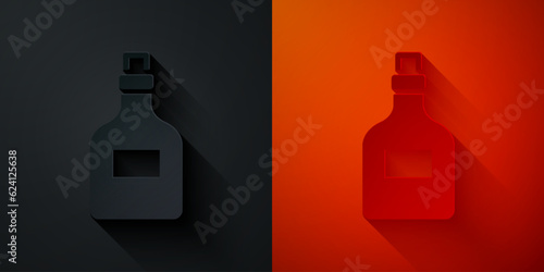 Paper cut Alcohol drink Rum bottle icon isolated on black and red background. Paper art style. Vector