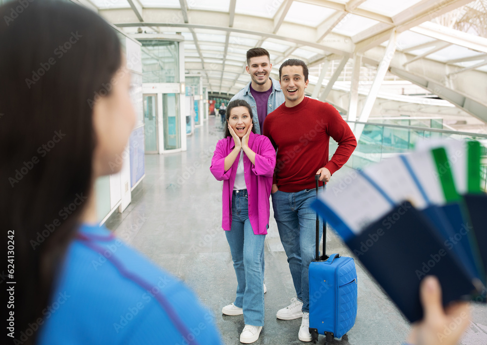 Travel Agent Showing Tickets To Joyful Tourists Trio At Airport