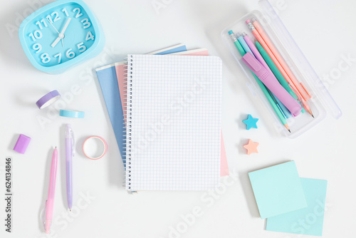 Back to school background. Flat lay, top view of school accessories, school pencil case with filling school stationery, notebook, pens on isolated white table background. School stationery on desk. 
