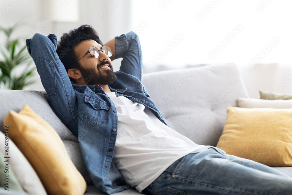 Domestic Rest. Young Handsome Indian Guy Leaning Back On Couch At Home Domestic Rest. Young Handsome Indian Guy Leaning Back On Couch At Home