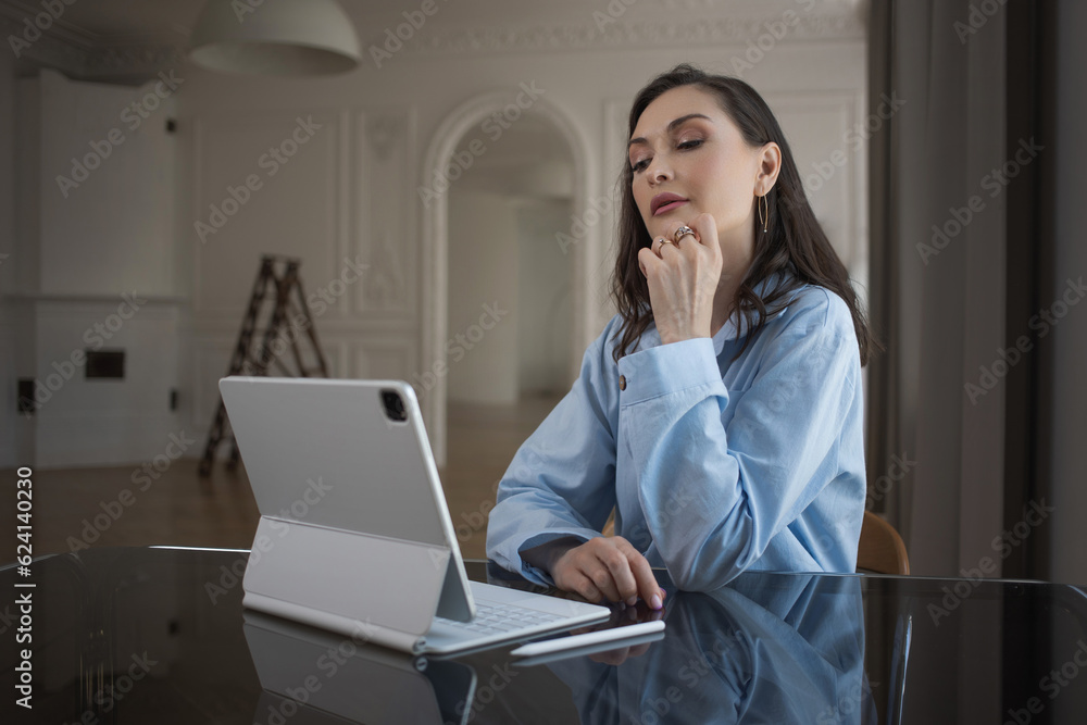 A business woman in a loose blue suit works remotely, working with text, a writer or a copywriter. A workplace in a pleasant home office, A business woman in a loose blue suit works remotely, working with text, a writer or a copywriter. A workplace in a pleasant home office,