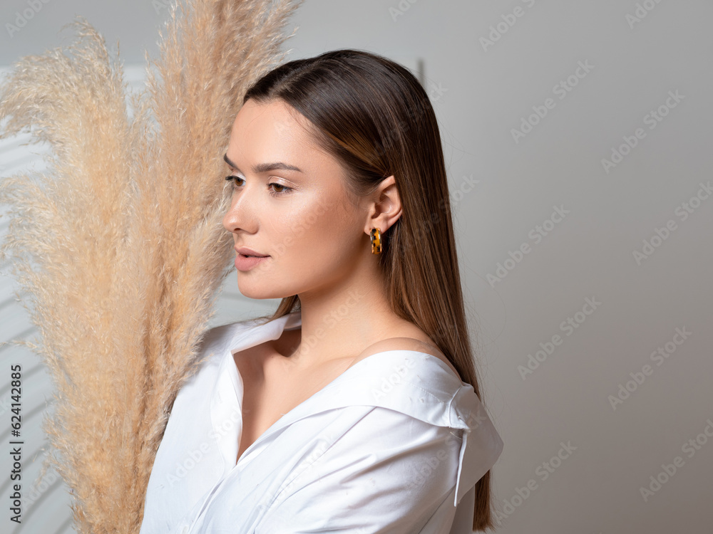 Cute and natural young brunette in the interior in light colors, style and natural beauty,beige tones, minimalistic style Cute and natural young brunette in the interior in light colors, style and natural beauty,beige tones, minimalistic style
