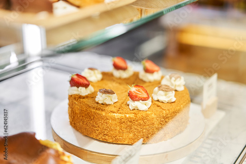 Honey cake with strawberries. fresh pastries with berries. A variety of fresh pastries in the bakery window. Strawberry cake. The interior of an Italian restaurant.