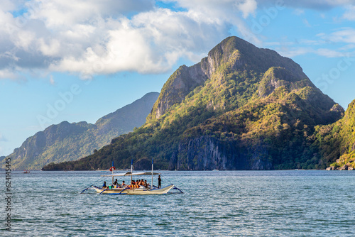Tropical island landscape with bangca traditional philippines boat full of tourist, El Nido, Palawan, Philippines