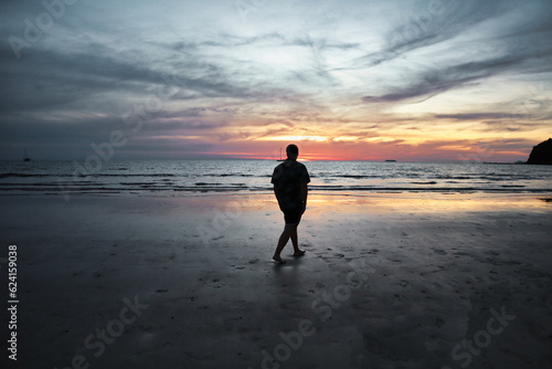 Man walking alone on the beach in Thailand