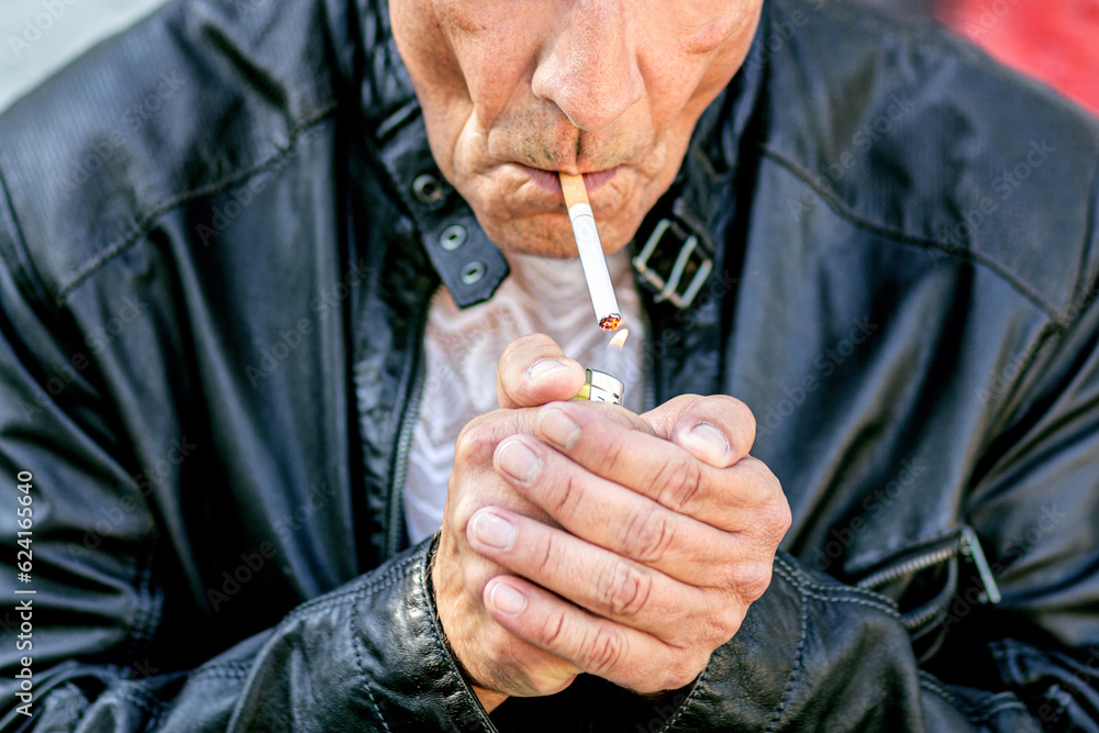 Close-up of a male smoking person wearing a leather jacket