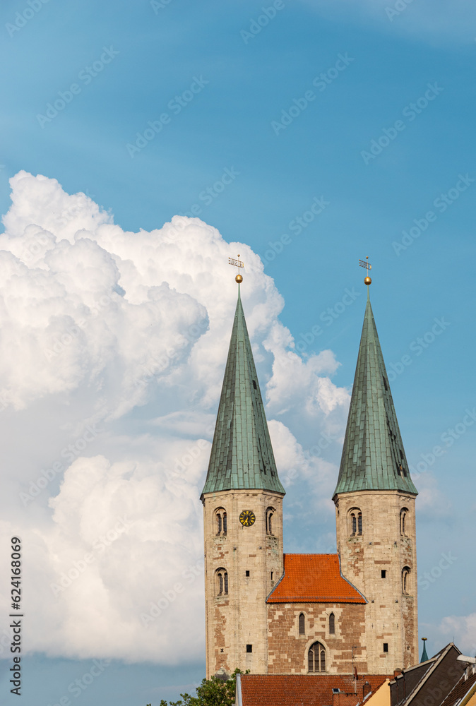 Two medieval towers of the Church of St. Martini against the blue sky and white clouds with copy space. Sights of the old town of Braunschweig, Germany.