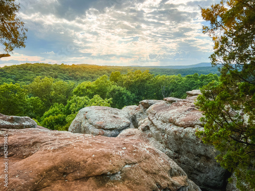 Breathtaking views standing at the top of the natural sandstone rock formations at Garden of the Gods, located within Shawnee National Forest. Standing at the top, looking out over a lush green forest © Sanya Kushak