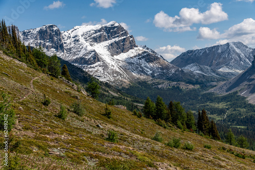 Wilderness views in Banff National Park during summer time with snow capped mountains on a blue sky, clouds day. Beautiful nature in Alberta, British Columbia